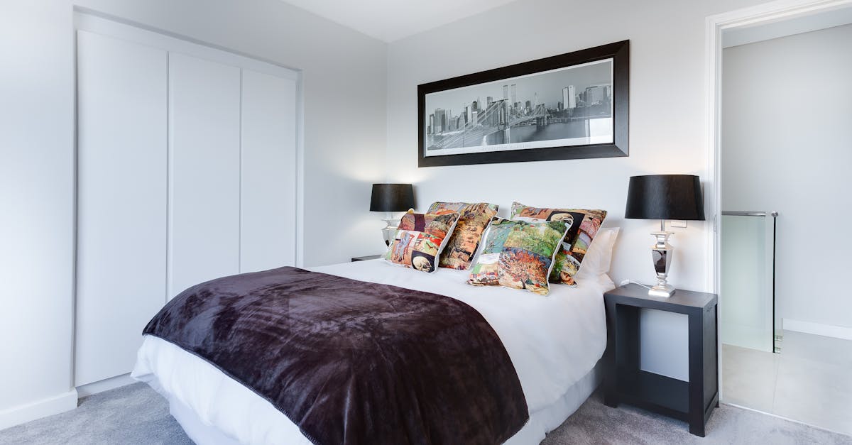 Stylish and contemporary bedroom featuring a cityscape artwork, colorful pillows, and modern decor.