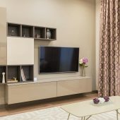 Elegant living room with modern furniture, TV, and stylish decor.